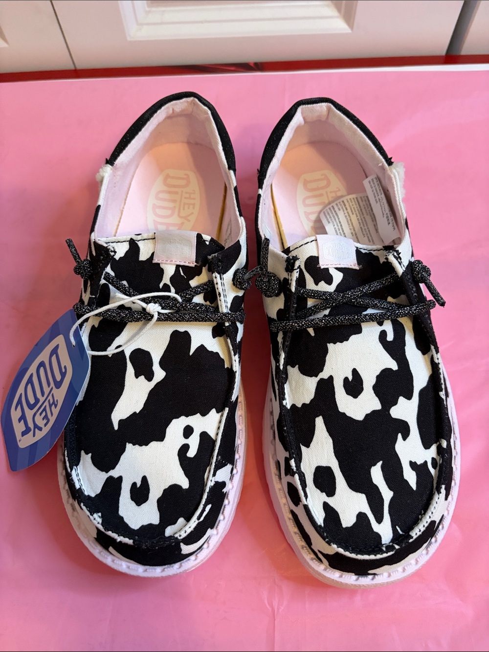 Hey Dude women Cow-Print Slip-On Sneakers in Black and White